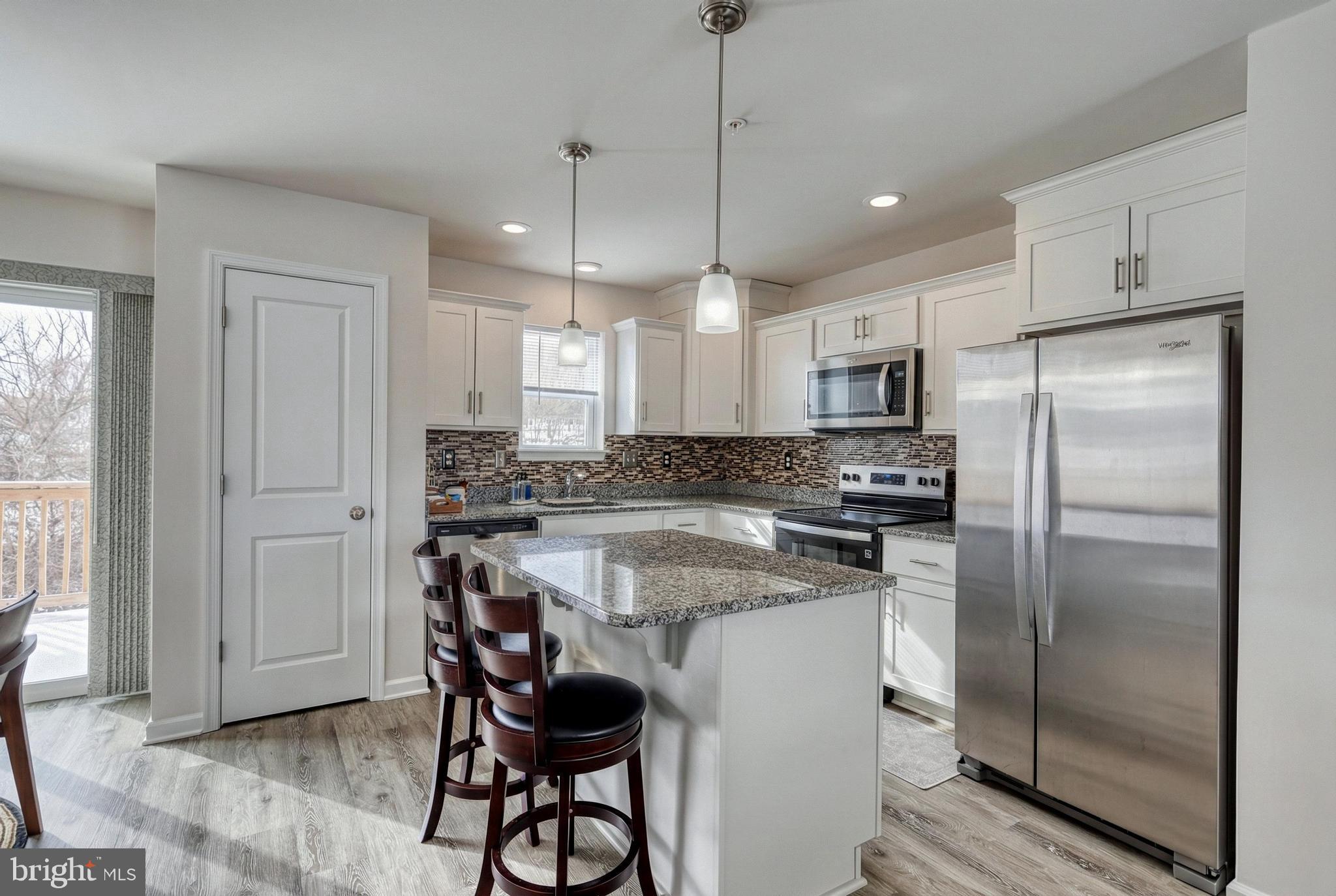 1 Landing Place, Unit 1 York, PA 17408 - Photo 10 of 48 a kitchen with kitchen island granite countertop a refrigerator a sink a stove a dining table and chairs