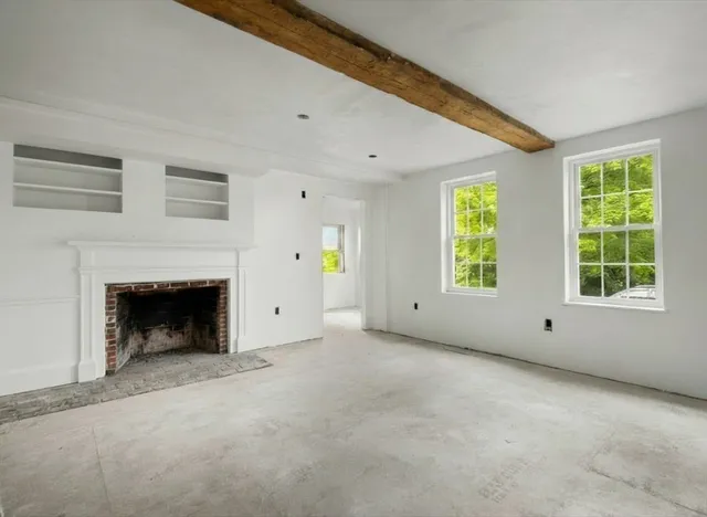 a view of empty room with windows and fireplace