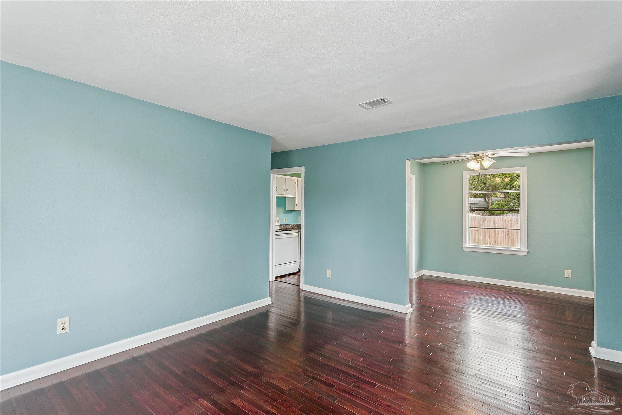 100 Milton Road Pensacola, FL 32507 - Photo 13 of 28 an empty room with wooden floor and windows