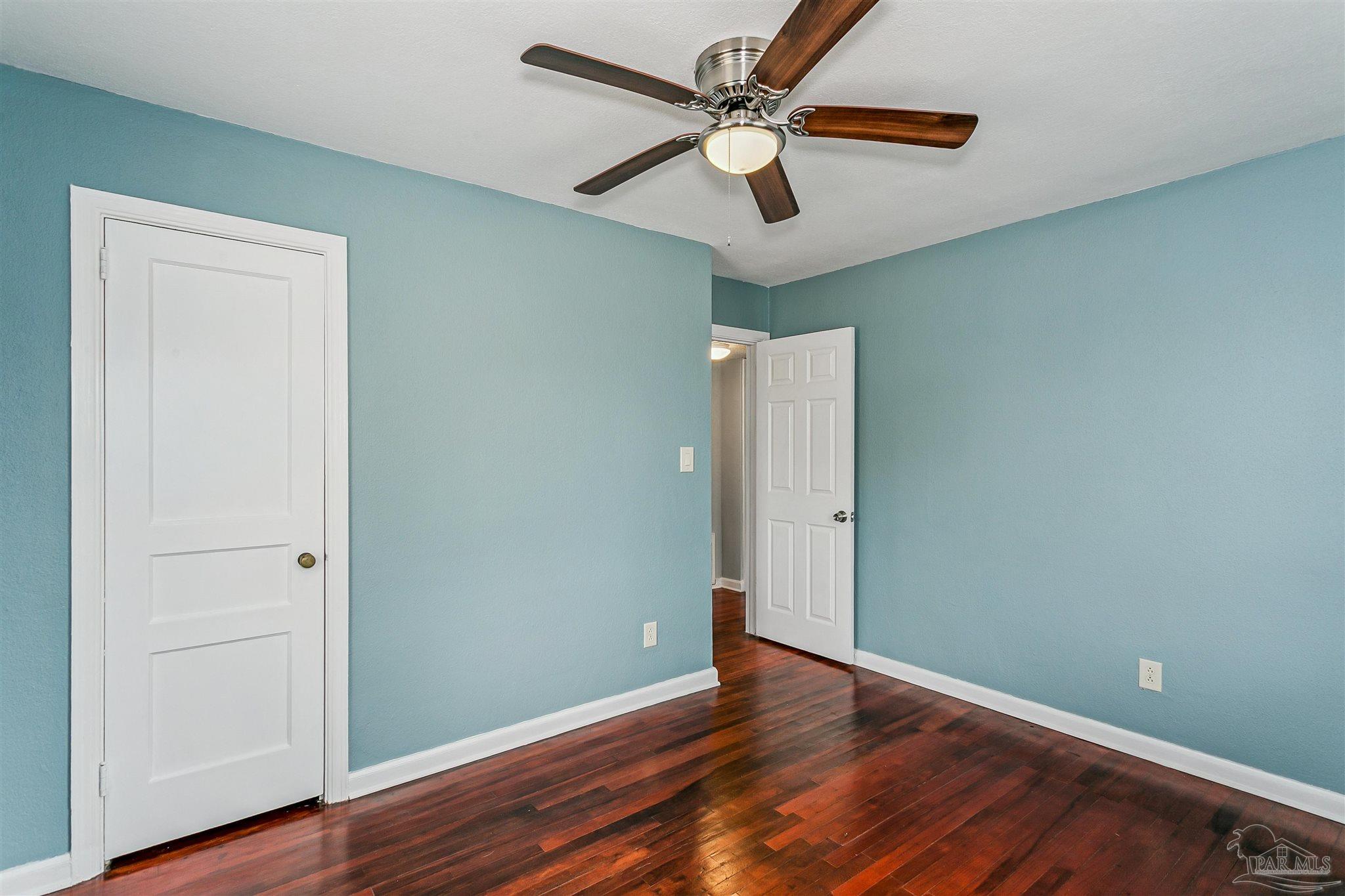100 Milton Road Pensacola, FL 32507 - Photo 19 of 28 an empty room with wooden floor fan and windows