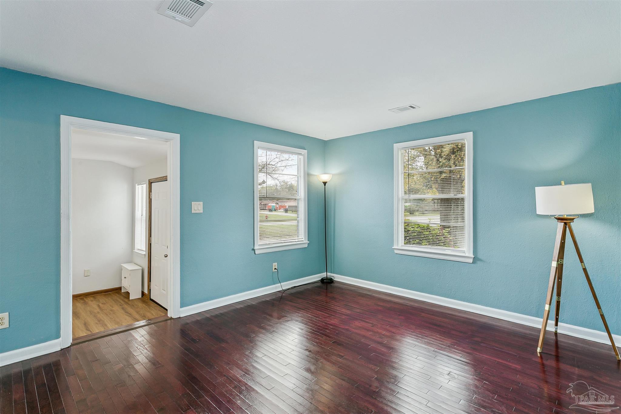 100 Milton Road Pensacola, FL 32507 - Photo 8 of 28 an empty room with wooden floor and windows