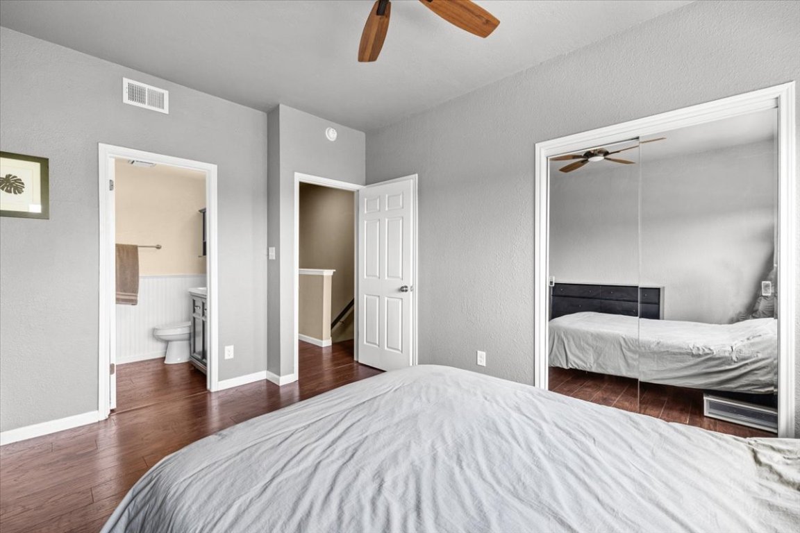 2605 Enfield Road, Unit 209 Austin, TX 78703 - Photo 16 of 29 a bedroom with a bed and wooden floor