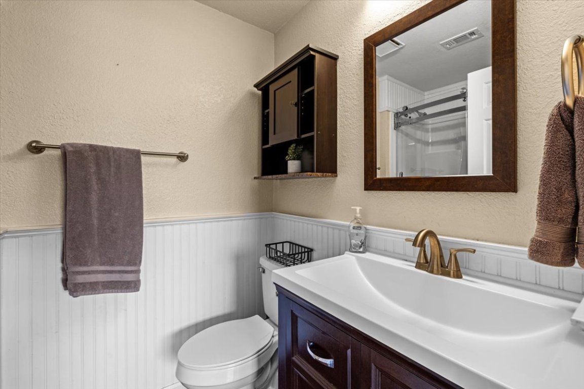 2605 Enfield Road, Unit 209 Austin, TX 78703 - Photo 17 of 29 a bathroom with a sink a toilet and mirror