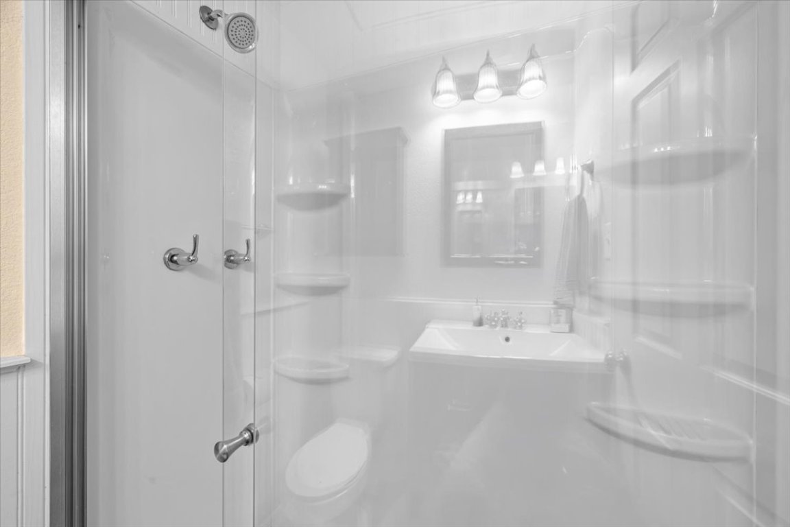 2605 Enfield Road, Unit 209 Austin, TX 78703 - Photo 24 of 29 a bathroom with a shower a sink and a mirror