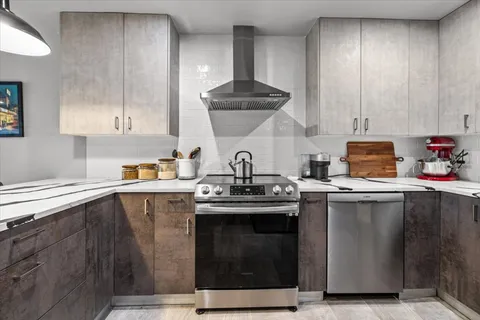 a kitchen with stainless steel appliances a sink stove and cabinets