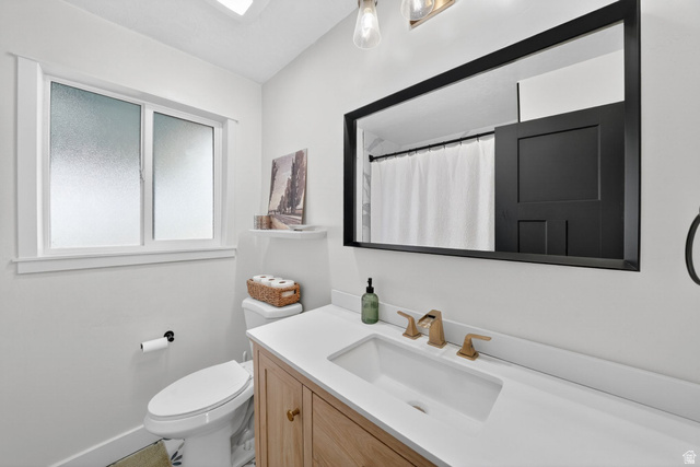 66 South 425 West Bountiful, UT 84010 - Photo 14 of 25 Modern bathroom vanity with a single basin, gold-finish faucet, and a large black-framed mirror