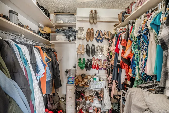 a view of walk in closet with clothes