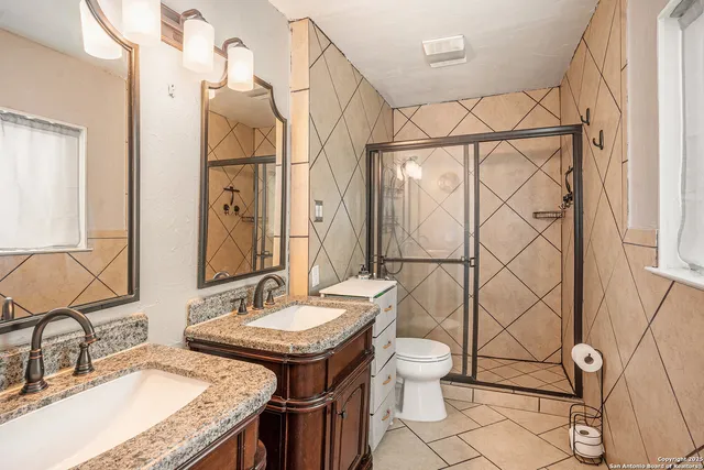 a bathroom with a granite countertop sink and a mirror