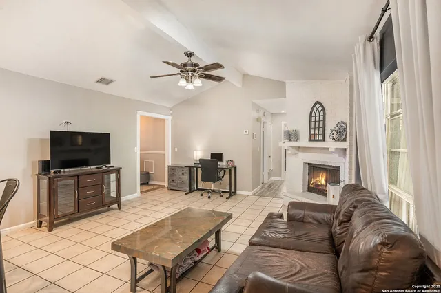 a living room with furniture a fireplace and flat screen tv