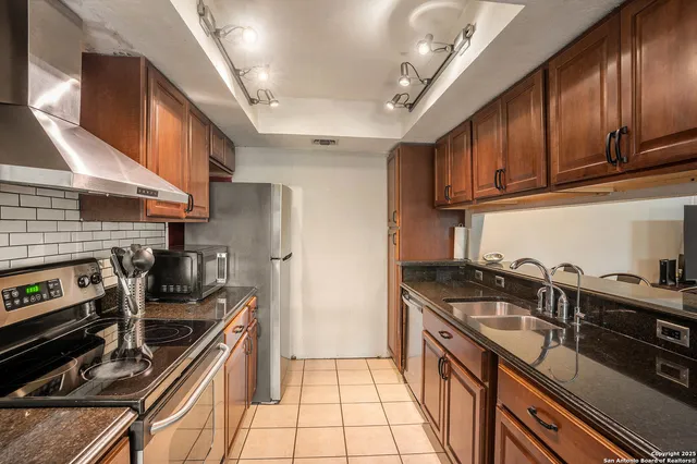 a kitchen with stainless steel appliances granite countertop a stove and a refrigerator