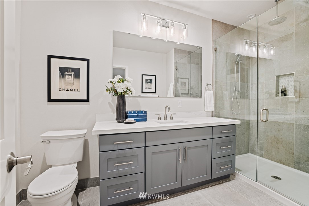 16900 Talbot Road Edmonds, WA 98026 - Photo 35 of 40 a bathroom with a toilet a sink a glass door a shower a and mirror