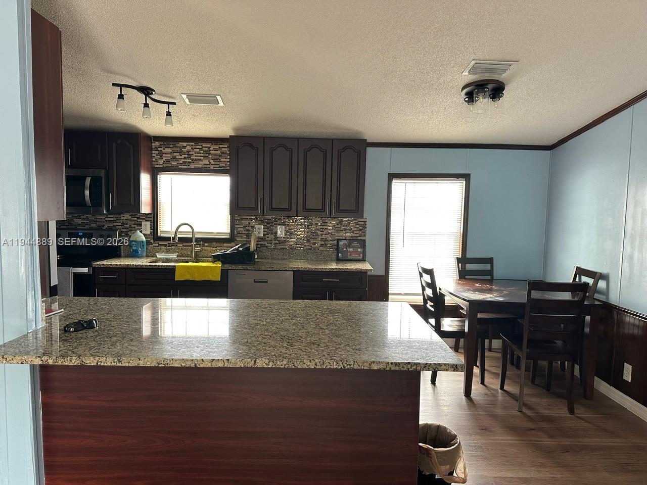 1122 Johnson Road Clewiston, FL 33440 - Photo 3 of 26 a kitchen with a table chairs and a sink