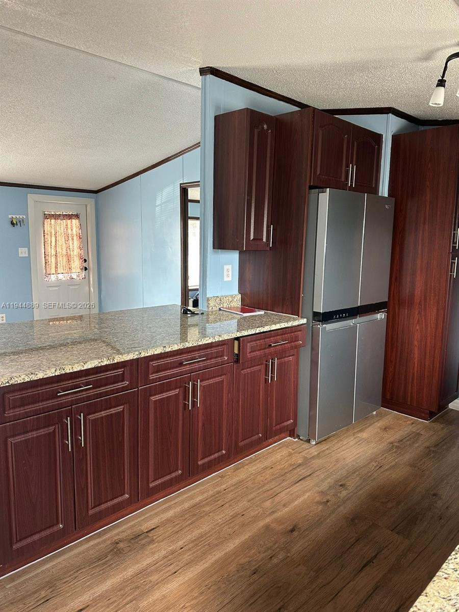 1122 Johnson Road Clewiston, FL 33440 - Photo 4 of 26 a kitchen with wooden cabinets stainless steel appliances and a window