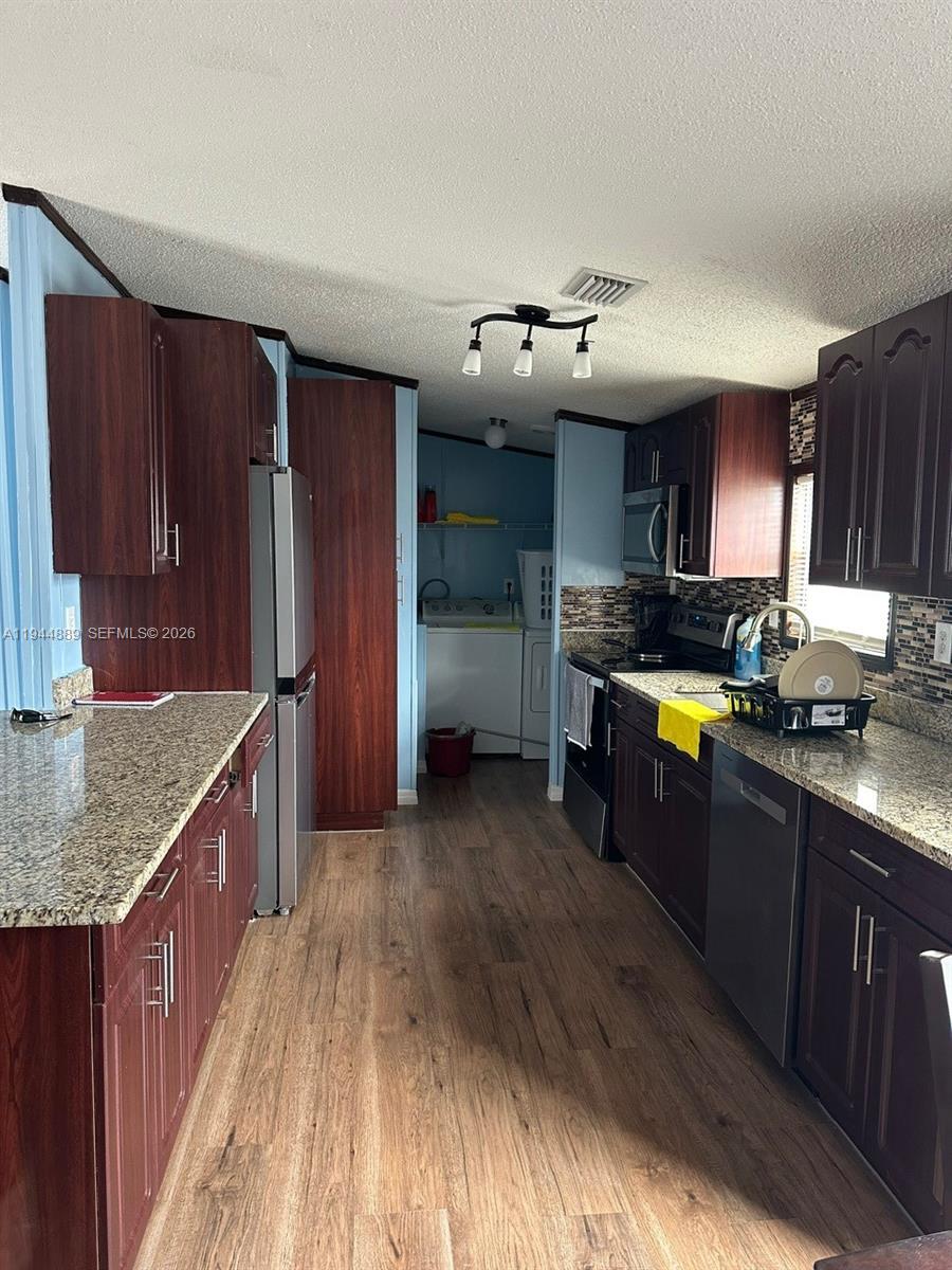 1122 Johnson Road Clewiston, FL 33440 - Photo 6 of 26 a kitchen with stainless steel appliances granite countertop a sink stove and refrigerator