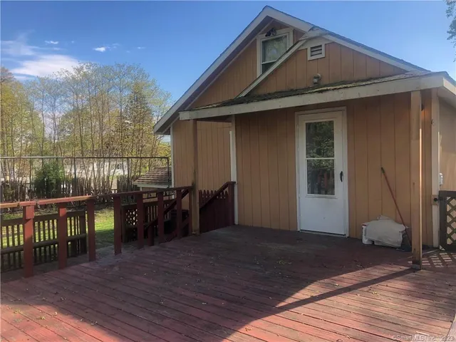 a view of a house with wooden deck and furniture