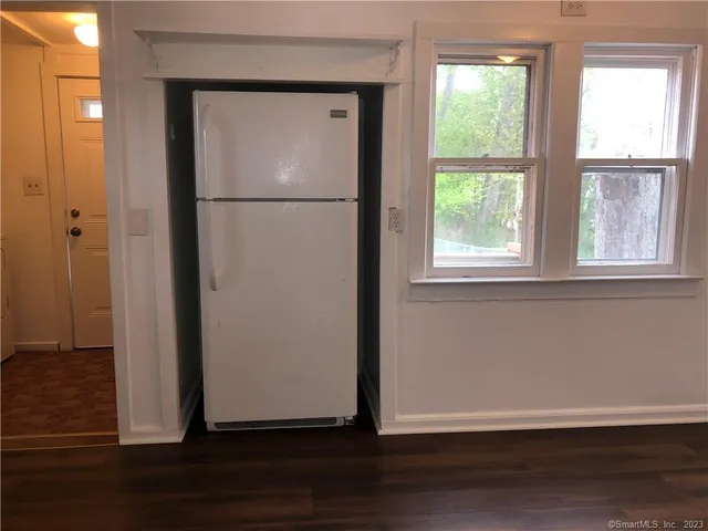 an empty room with wooden floor closet and windows