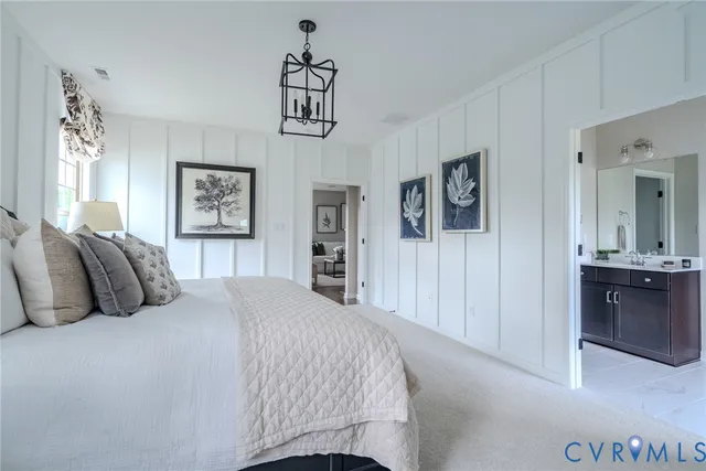 a bedroom with a large bed and a chandelier