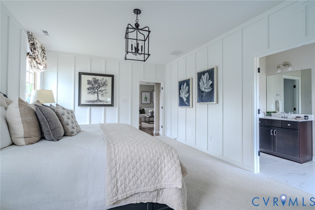 15790 Mosaic Creek Boulevard, Unit 231 Richmond, VA 23238 - Photo 15 of 25 a bedroom with a large bed and a chandelier