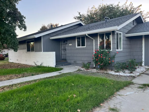 a front view of a house with a garden and yard
