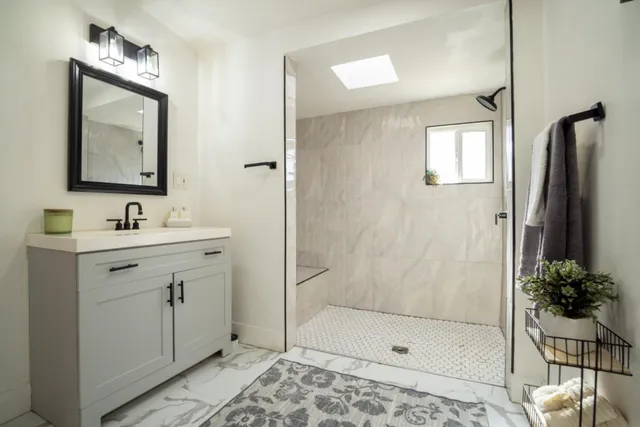 a bathroom with a shower sink and mirror