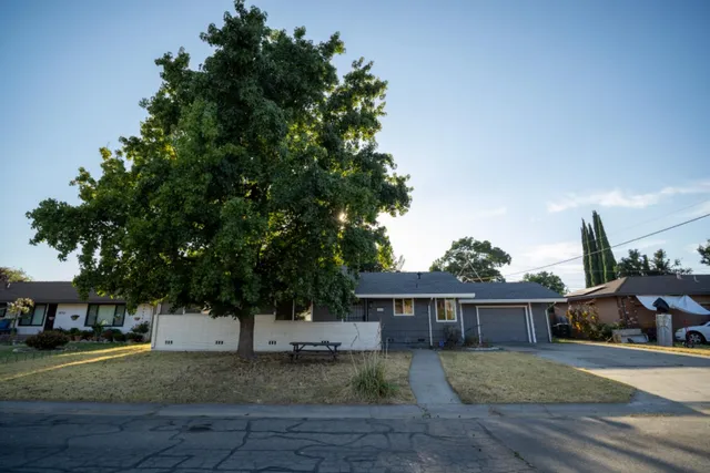 a front view of a house with a yard and trees