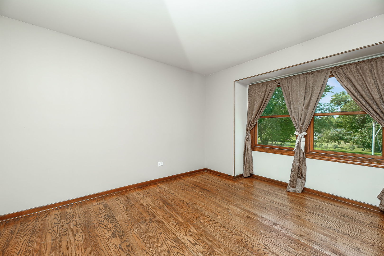 6N476 Thorn Road Hanover Park, IL 60133 - Photo 15 of 35 an empty room with wooden floor and a floor to ceiling window