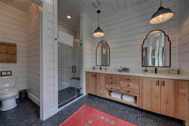 a bathroom with double vanity sink a toilet and a mirror