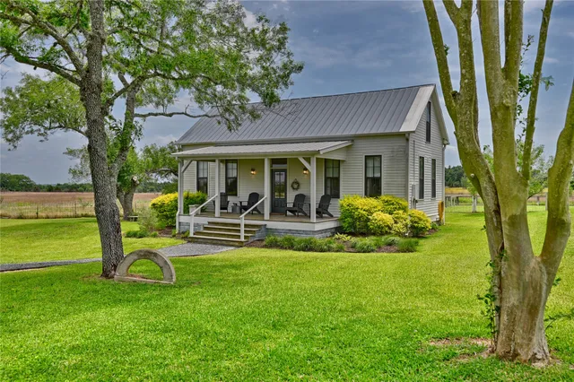 a view of a house with a patio and a yard