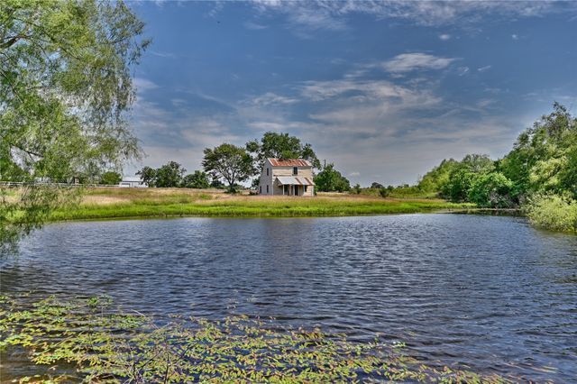 a view of a fountain in the middle of a green field