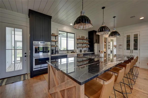 a kitchen with kitchen island a large counter top appliances and cabinets