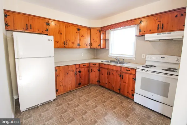 a kitchen with a sink a stove and a refrigerator