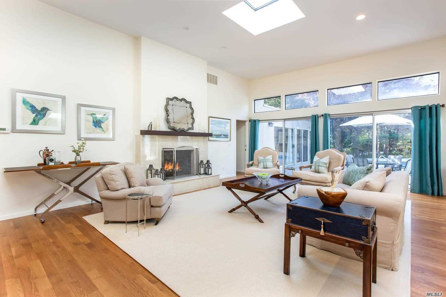 a living room with fireplace furniture and a large window