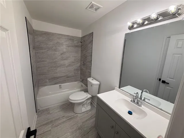 a bathroom with a sink mirror toilet and bathtub