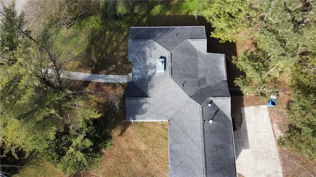 an aerial view of a house with a yard and trees