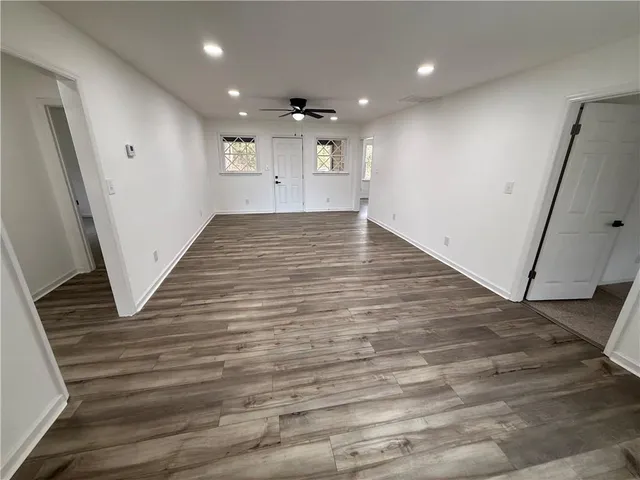 an empty room with wooden floor and entryway