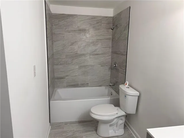 a bathroom with a toilet and a bath tub
