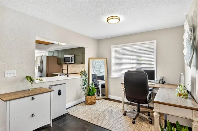 a view of a workspace with furniture and a window