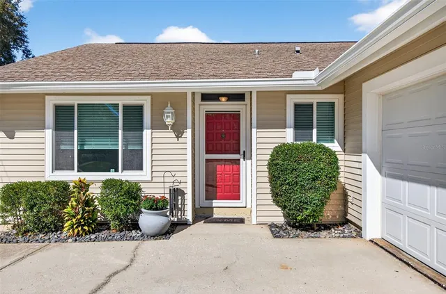 front view of a brick house with potted plants
