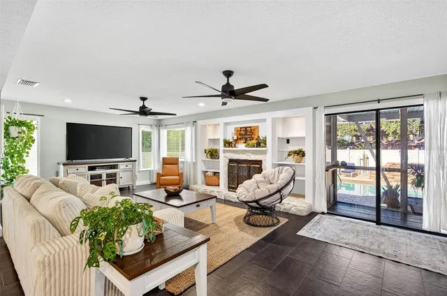 a living room with furniture floor to ceiling window hardwood floor and a flat screen tv