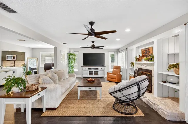 a living room with furniture a flat screen tv and a chandelier