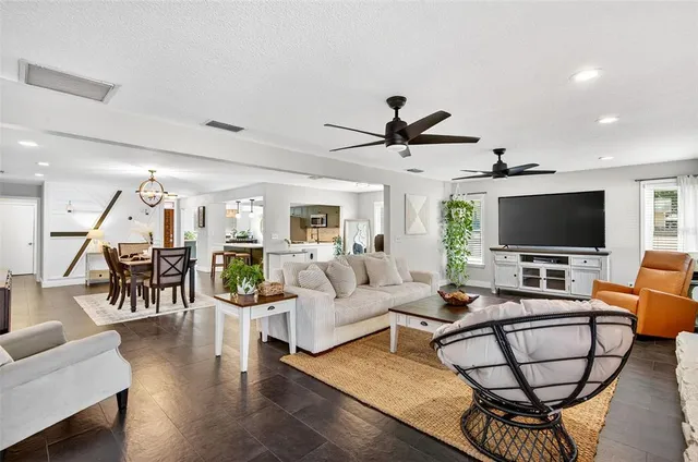 a living room with furniture and a flat screen tv with wooden floor