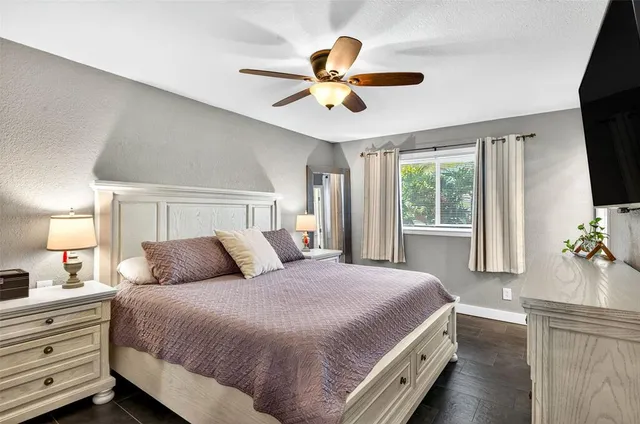 a bedroom with a large bed and a flat tv screen