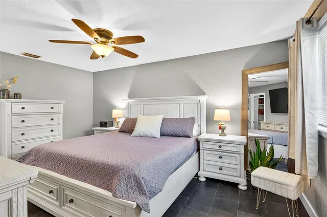 a bedroom with a bed a chandelier and a dresser