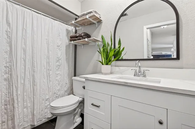 a bathroom with a sink a toilet and a mirror
