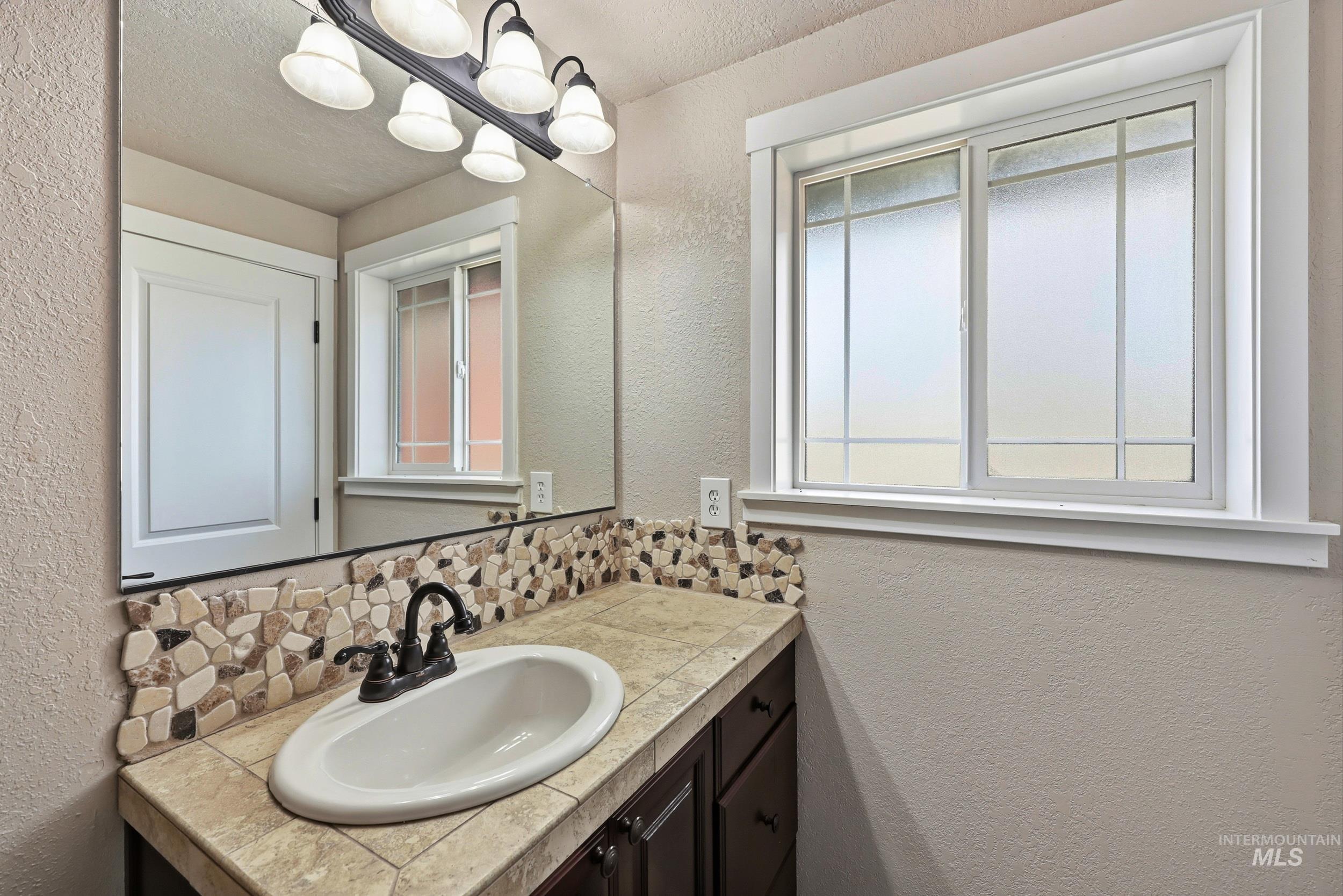 20203 Top Road Greenleaf, ID 83626 - Photo 12 of 16 Bathroom featuring a textured wall, vanity, and a textured ceiling