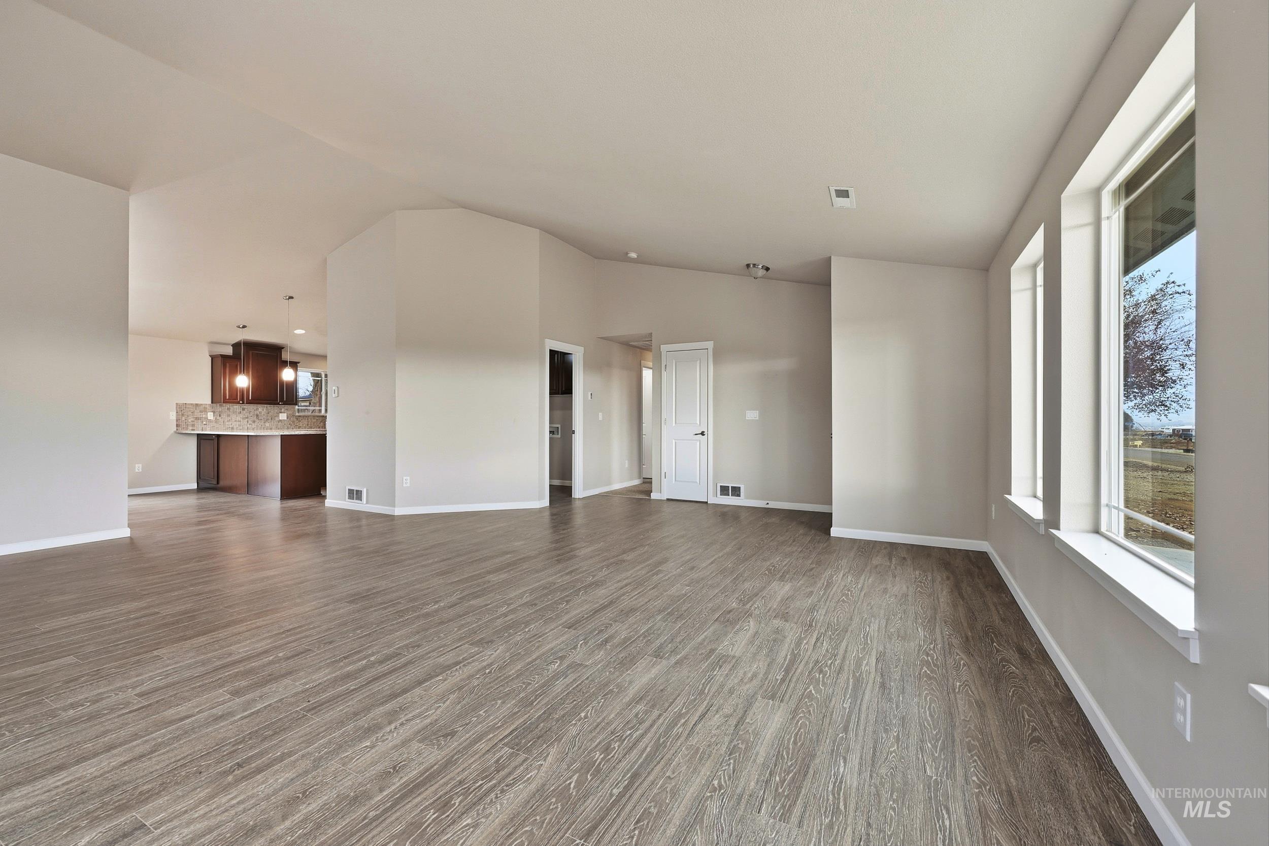 20203 Top Road Greenleaf, ID 83626 - Photo 13 of 16 Unfurnished living room featuring dark wood finished floors and baseboards