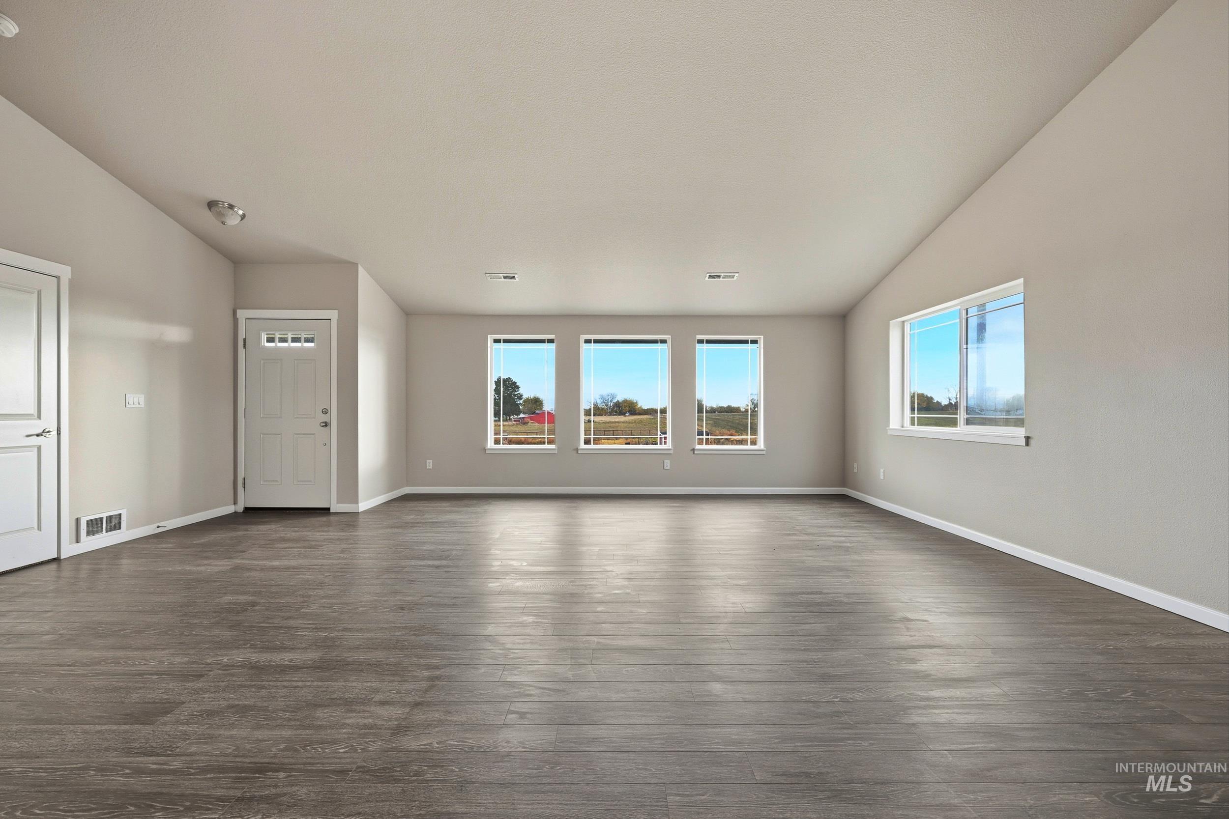 20203 Top Road Greenleaf, ID 83626 - Photo 9 of 16 Unfurnished living room with dark wood-type flooring and vaulted ceiling