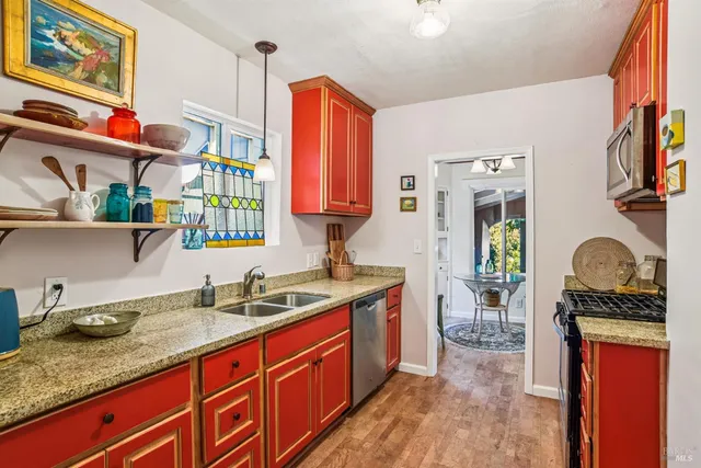 a kitchen with granite countertop a sink stove and cabinets
