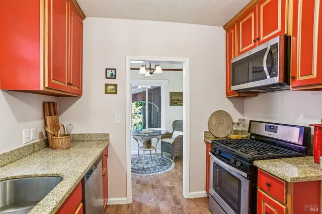 a kitchen with stainless steel appliances granite countertop a stove and a microwave