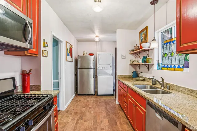 a kitchen with stainless steel appliances granite countertop a sink stove and refrigerator